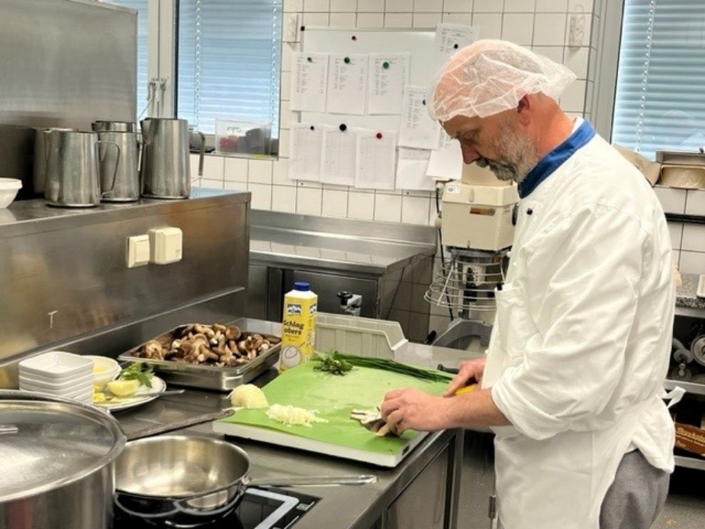 Der Küchenchef schneidet die Zwiebel.