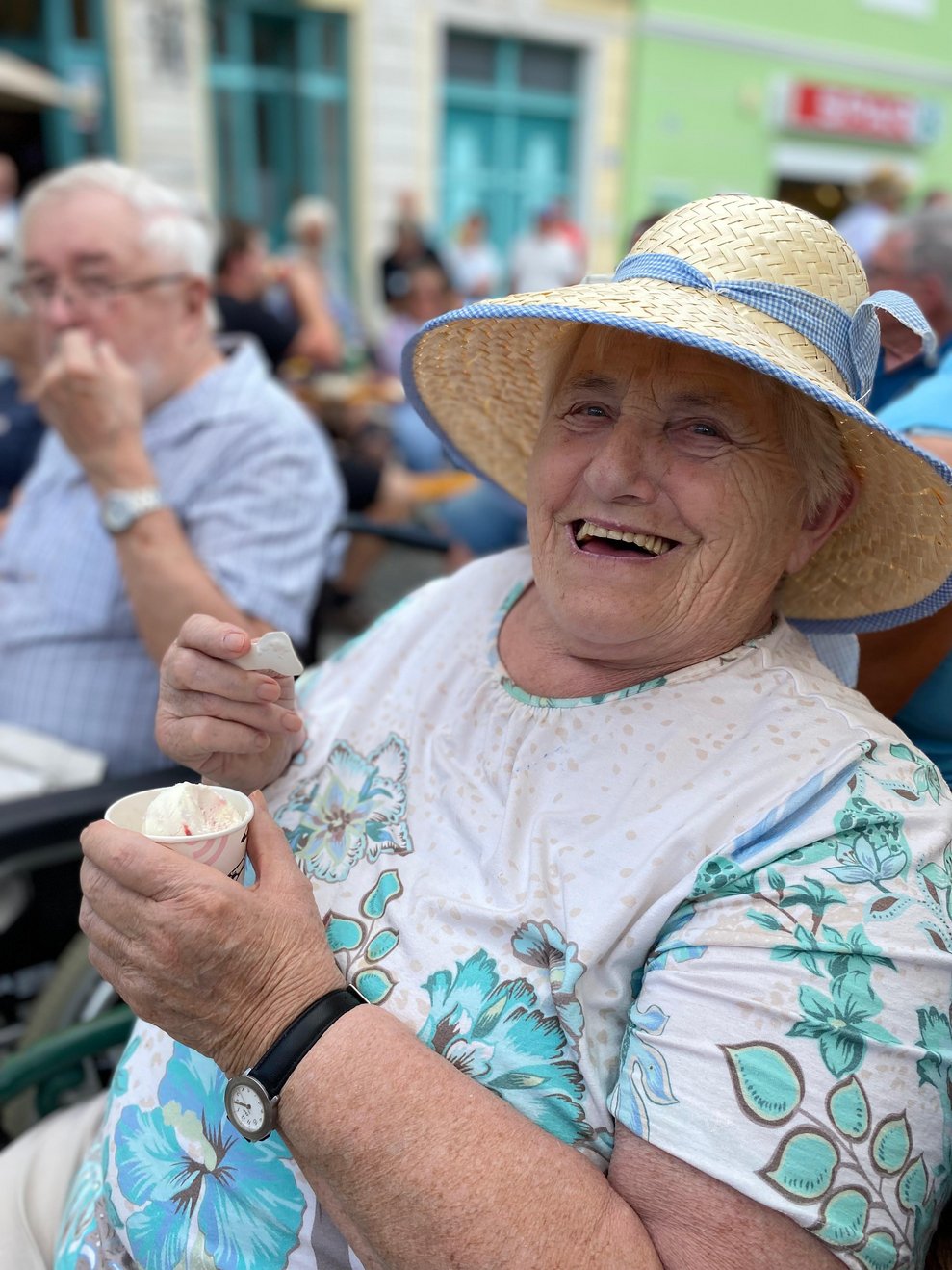 Frau lacht und isst ein Eis.