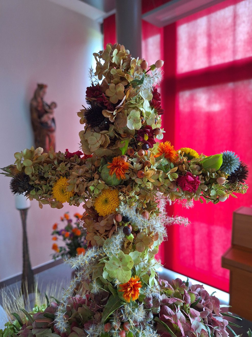 Das Kreuz thront am Kopf der Erntekrone. Es ist für die Christenheit das wichtigste Symbol, das auf die Erlösung der Menschheit von Leid und Tod durch Jesus Christus verweist. 