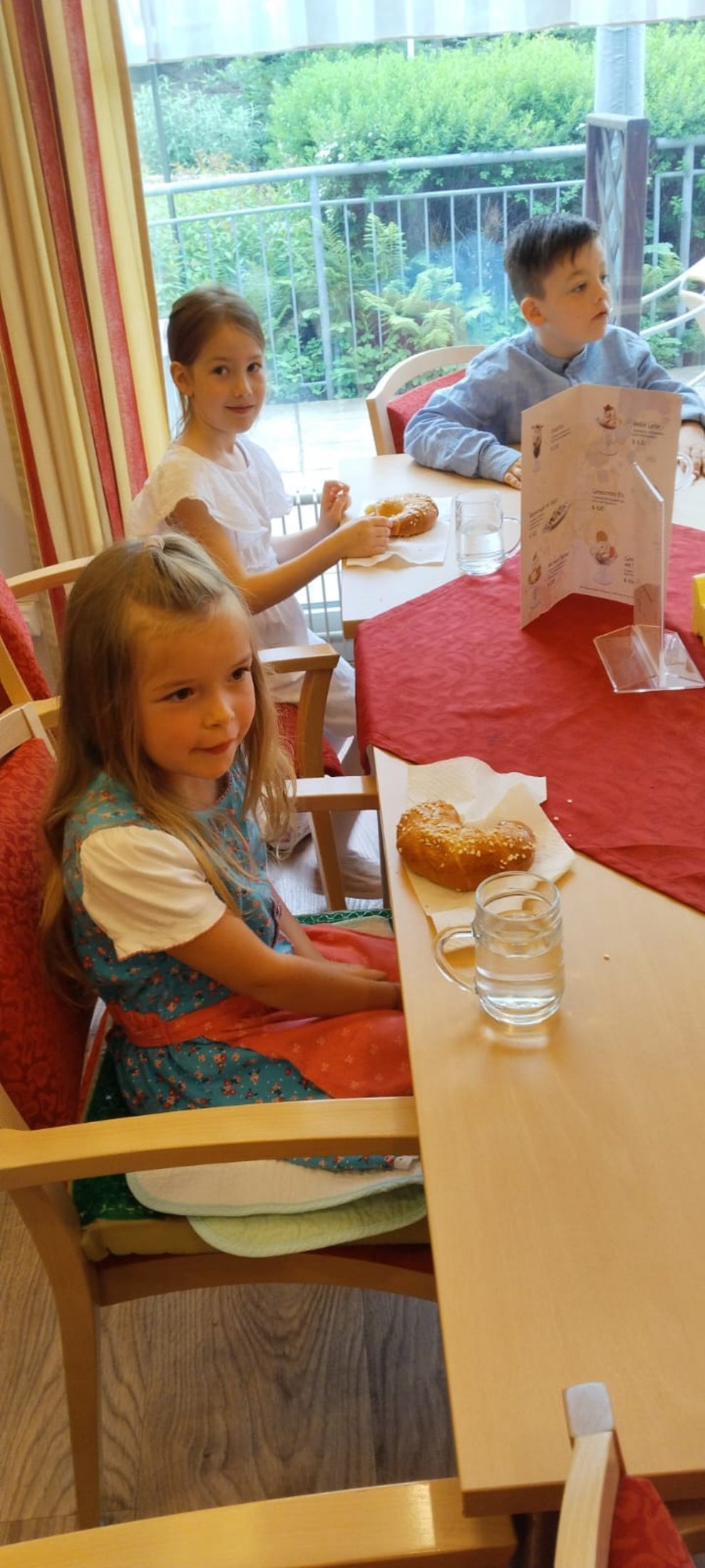 Zwei Mädchen und ein Bub bei der Jause.