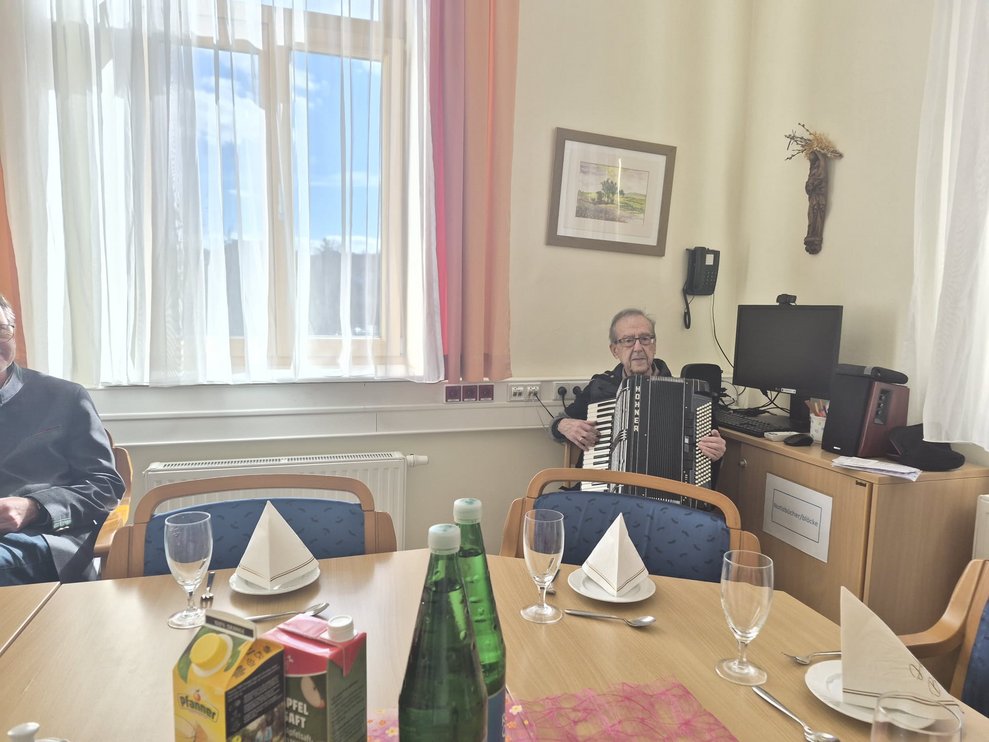 Sitzender Mann spielt Akkordeon.