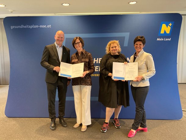 Drei Damen und ein Herr bei der Dekretübergabe.