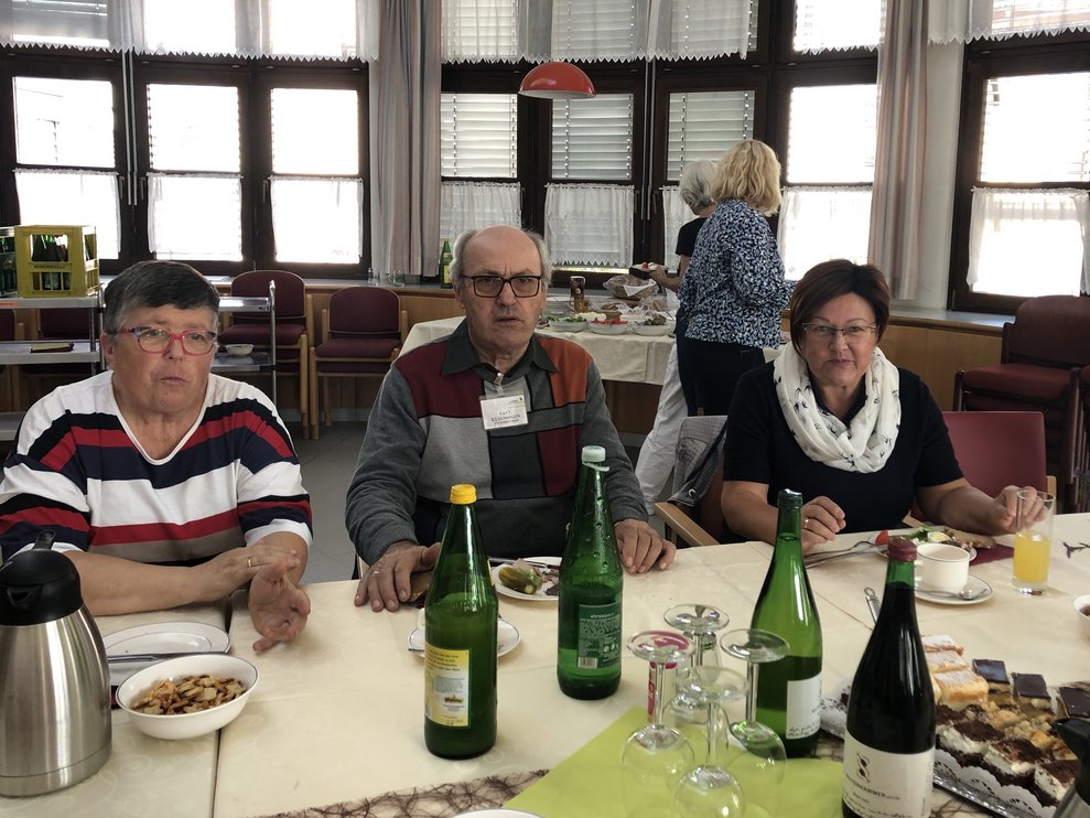 Zwei Damen und ein Herr bei der Jause. 