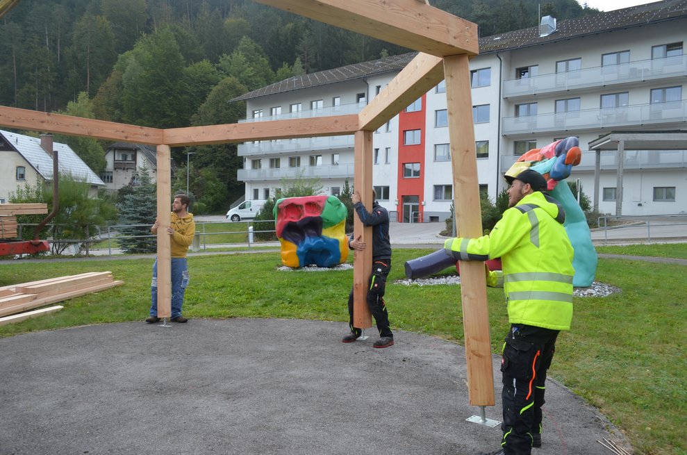 Jugendliche rücken das Holz zurecht.