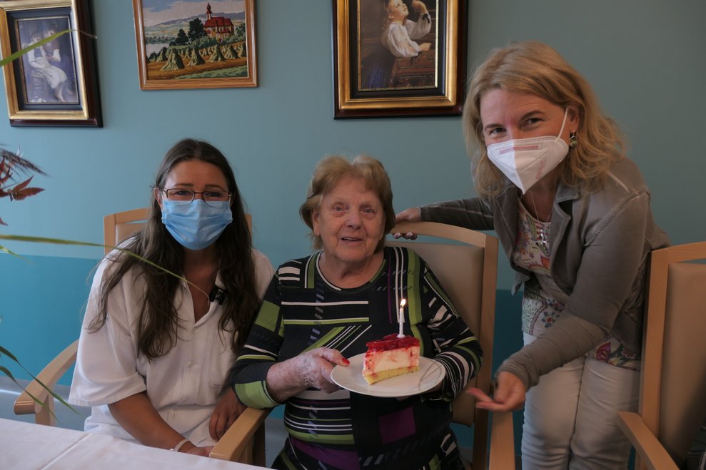 Drei Frauen mit einem Stück Torte.