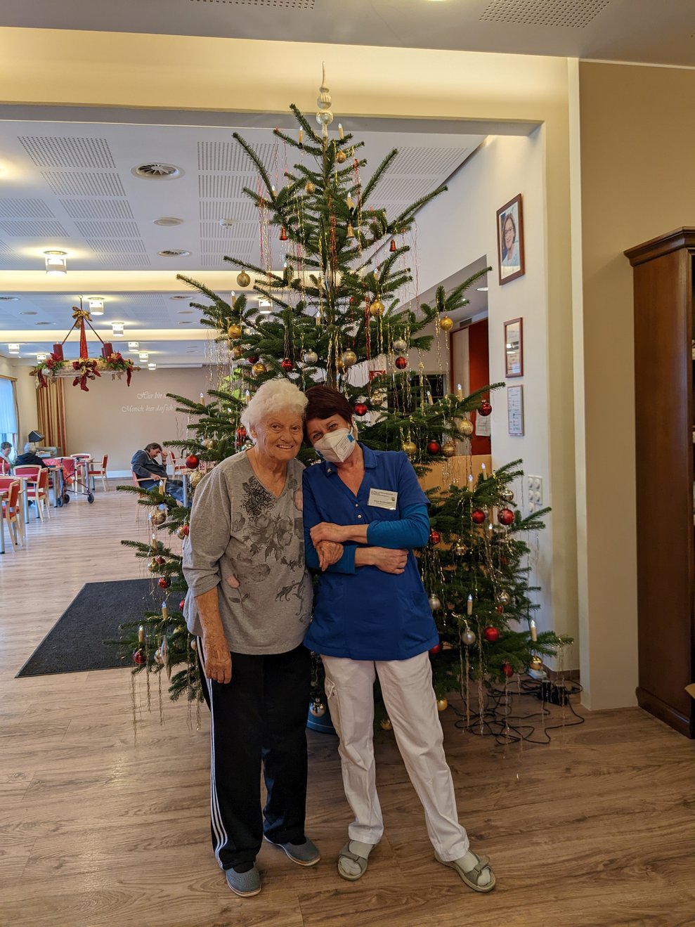 Zwei Damen posieren vorm Christbaum.