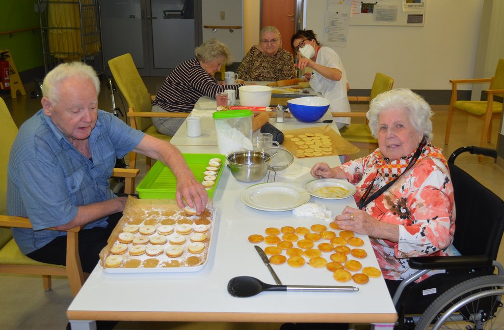 mehrere Bewohner im Speisesaal beim Backen