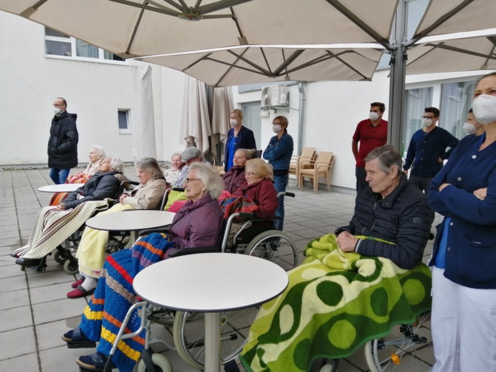 BewohnerInnen sitzen auf der Terrasse.