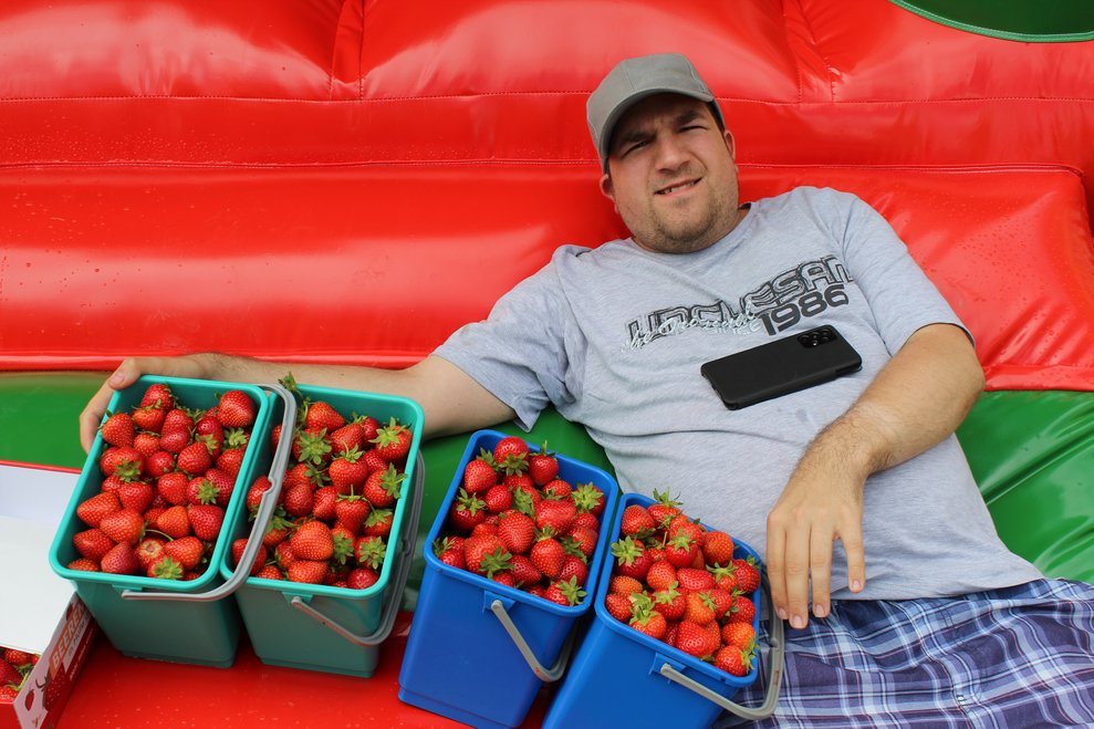 Eine Person mit vielen Erdbeeren.