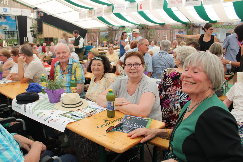 lachende Damen und ein Herr beim Tisch