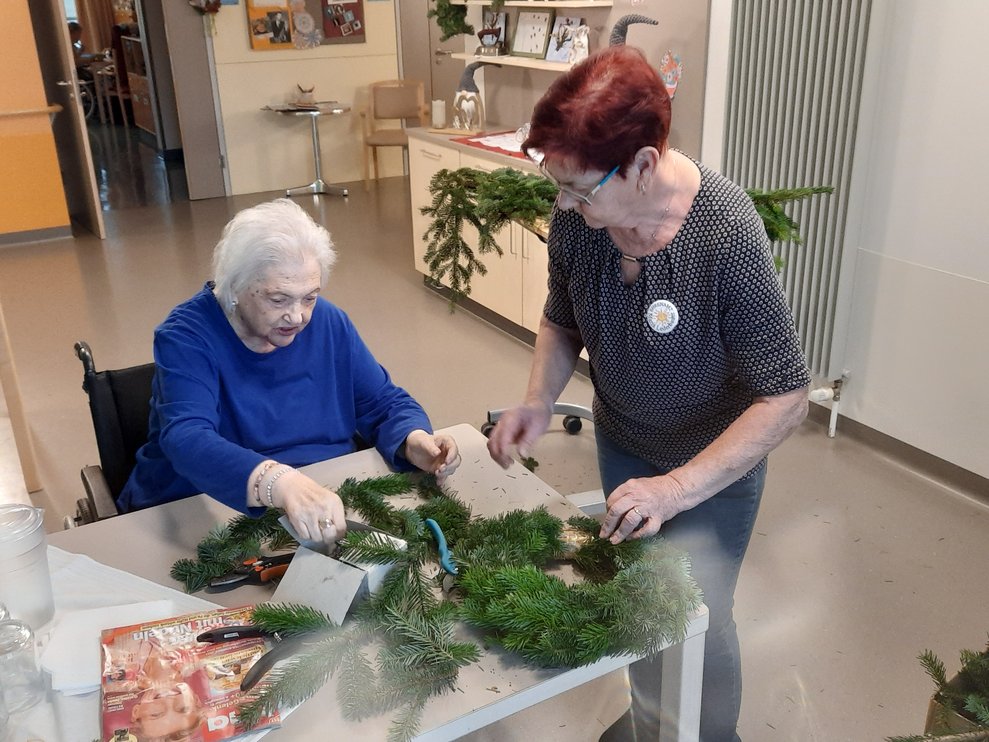 Zwei Damen beim Adventkranzbinden.