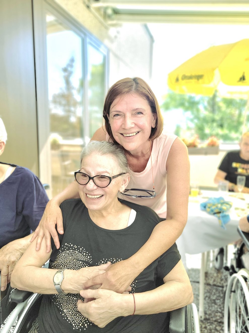 Pflege und Betreuungsmanagerin mit Frau M., beide erfreuen sich an den Köstlichkeiten.