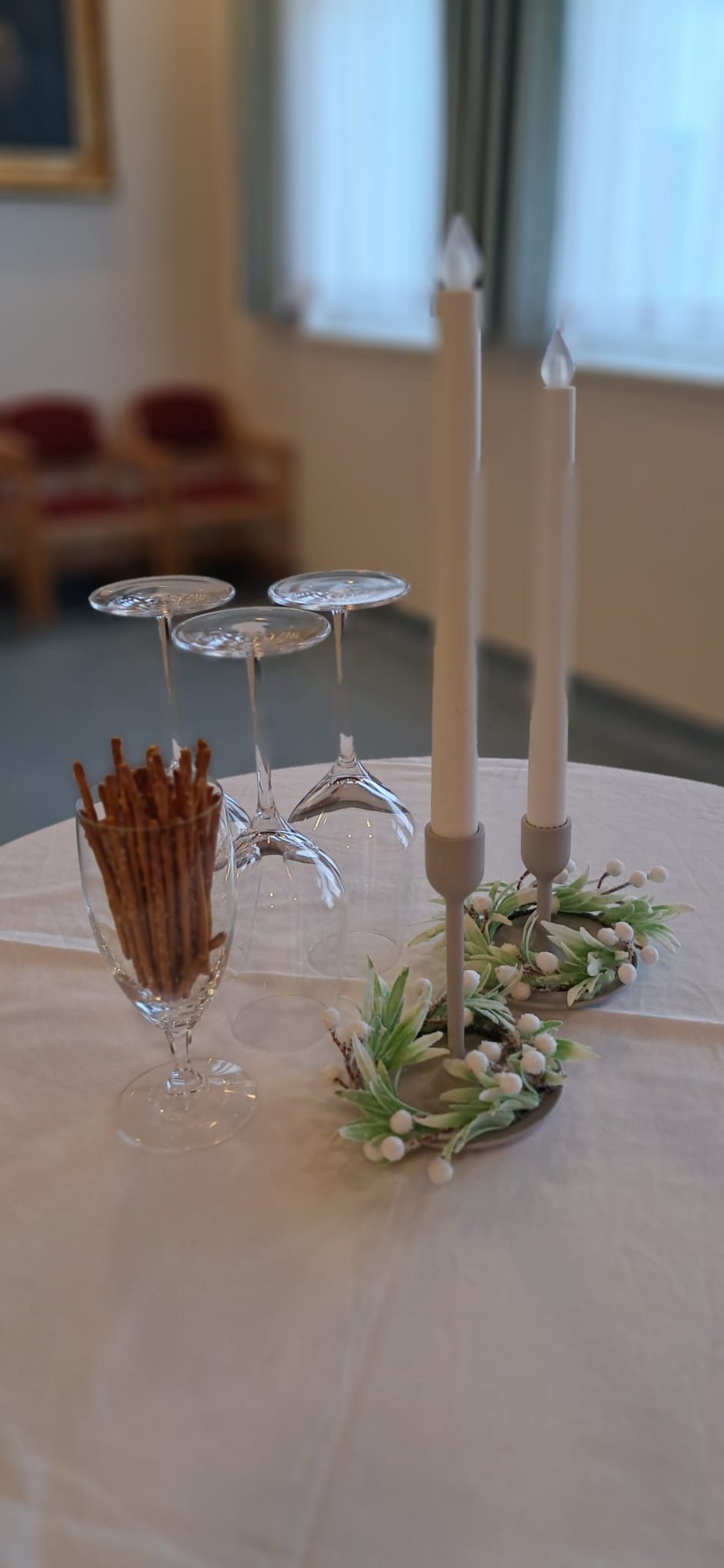 Tisch mit zwei langen Kerzen (nicht echt), umgedrehte Gläser, ein Glas mit Soletti.