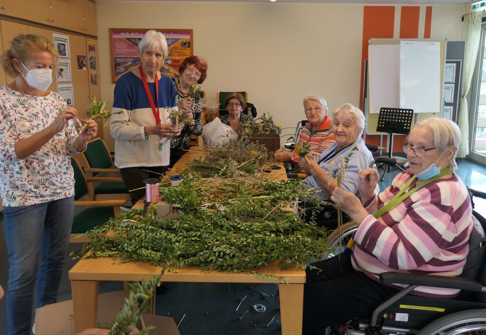 Sieben Frauen binden die Erntedanksträußchen.
