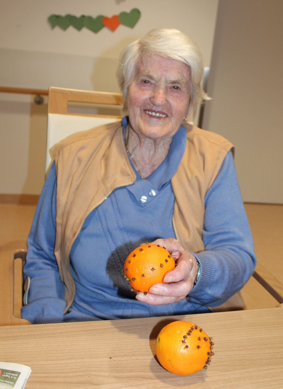 Eine Bewohnerin hält dekorierte Orangen.