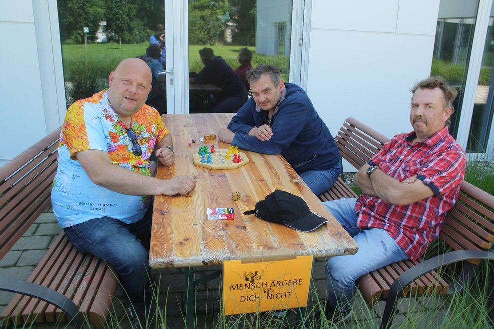 Personen sitzen bei einem Tisch und spielen