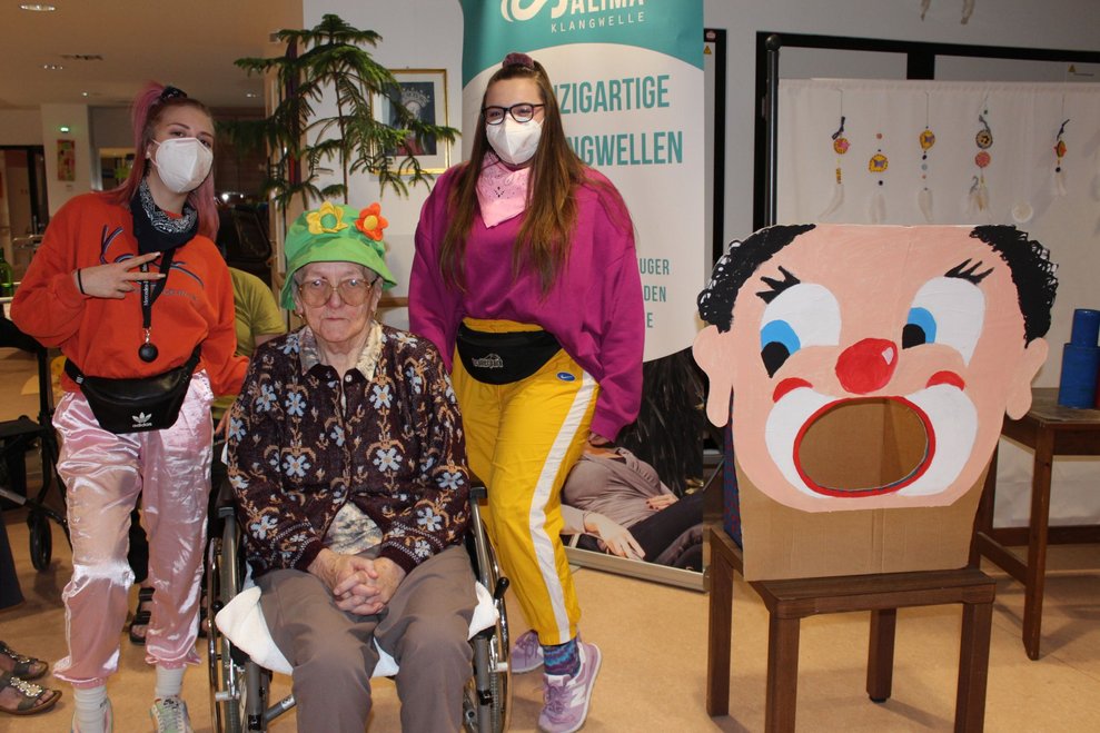 Zwei verkleidete Betreuerinnen stehen neben einer Bewohnerin.