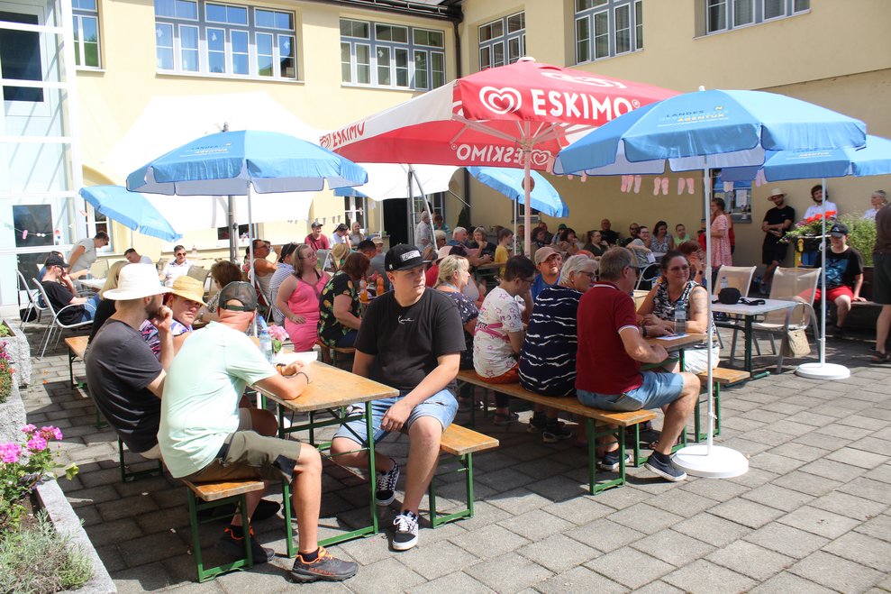 Viele Personen sitzen an Tischen.