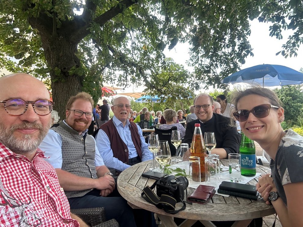 einige Personen bei Tisch im Garten
