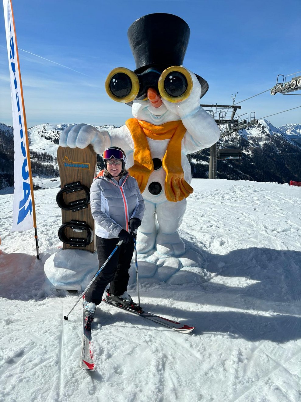 Eine Kollegin posiert vor einem aufgeblasenen Schneemann.