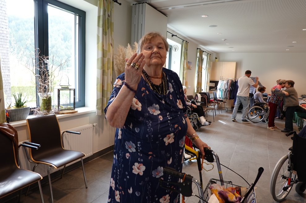 Bewohnerin mit Rollator präsentiert Blumenkleid