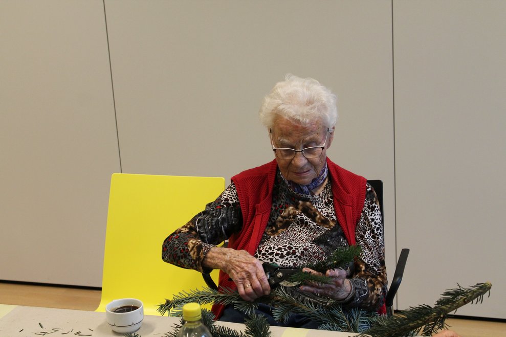 Frau beim Adventkranzbinden.