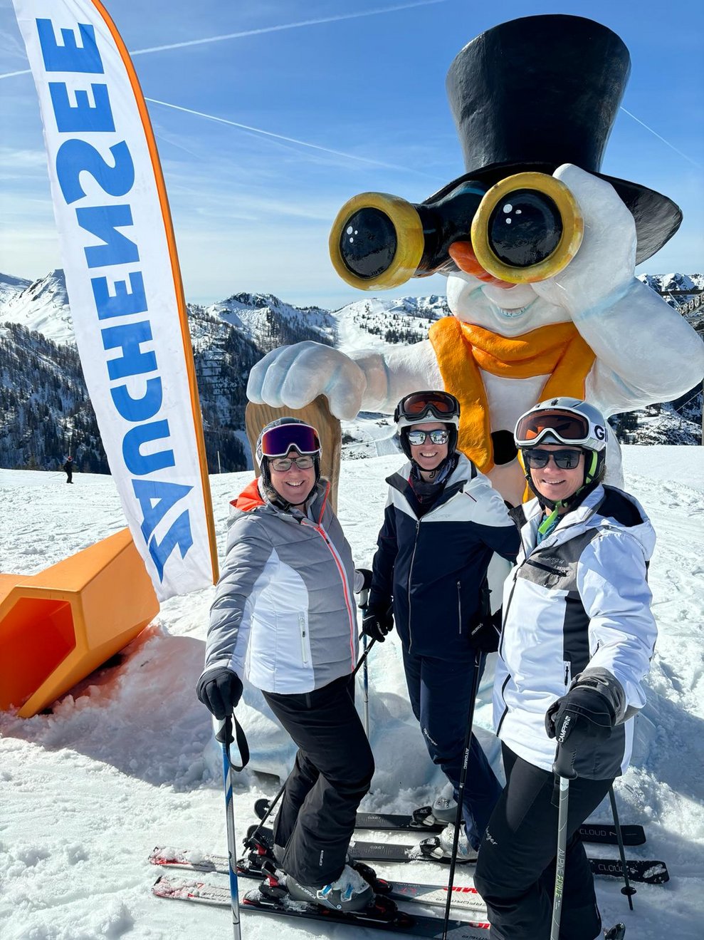 Drei Kolleginnen posieren vor dem aufgeblasenen Riesenschneemann.