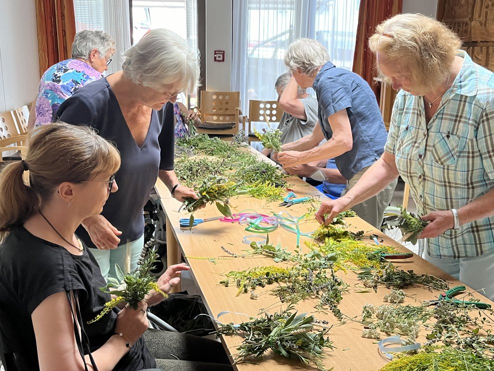 Menschen beim Kräuterbuschen binden