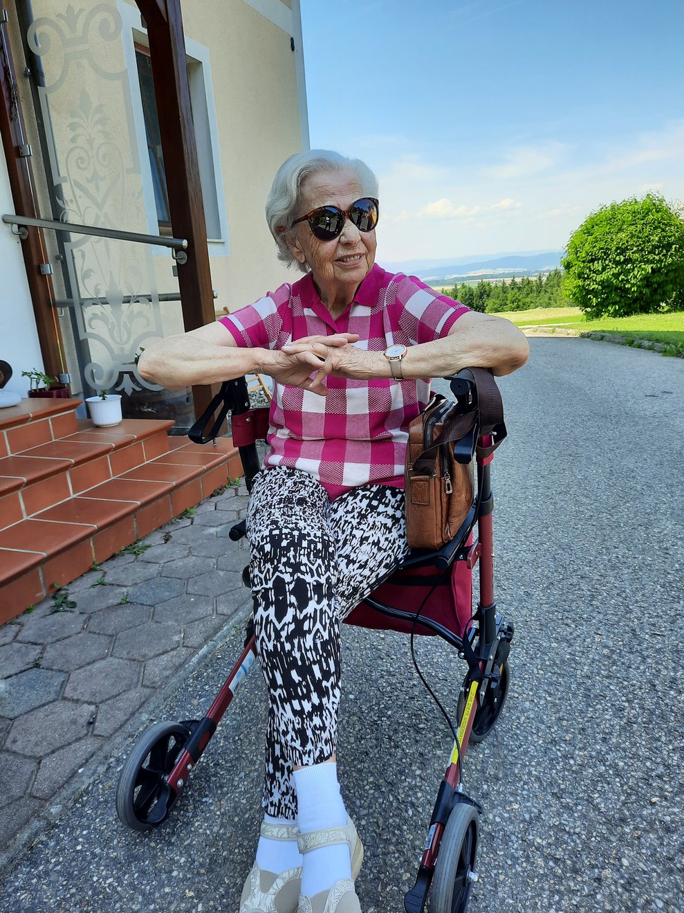 Eine Dame sitzt auf ihrem Rollator.