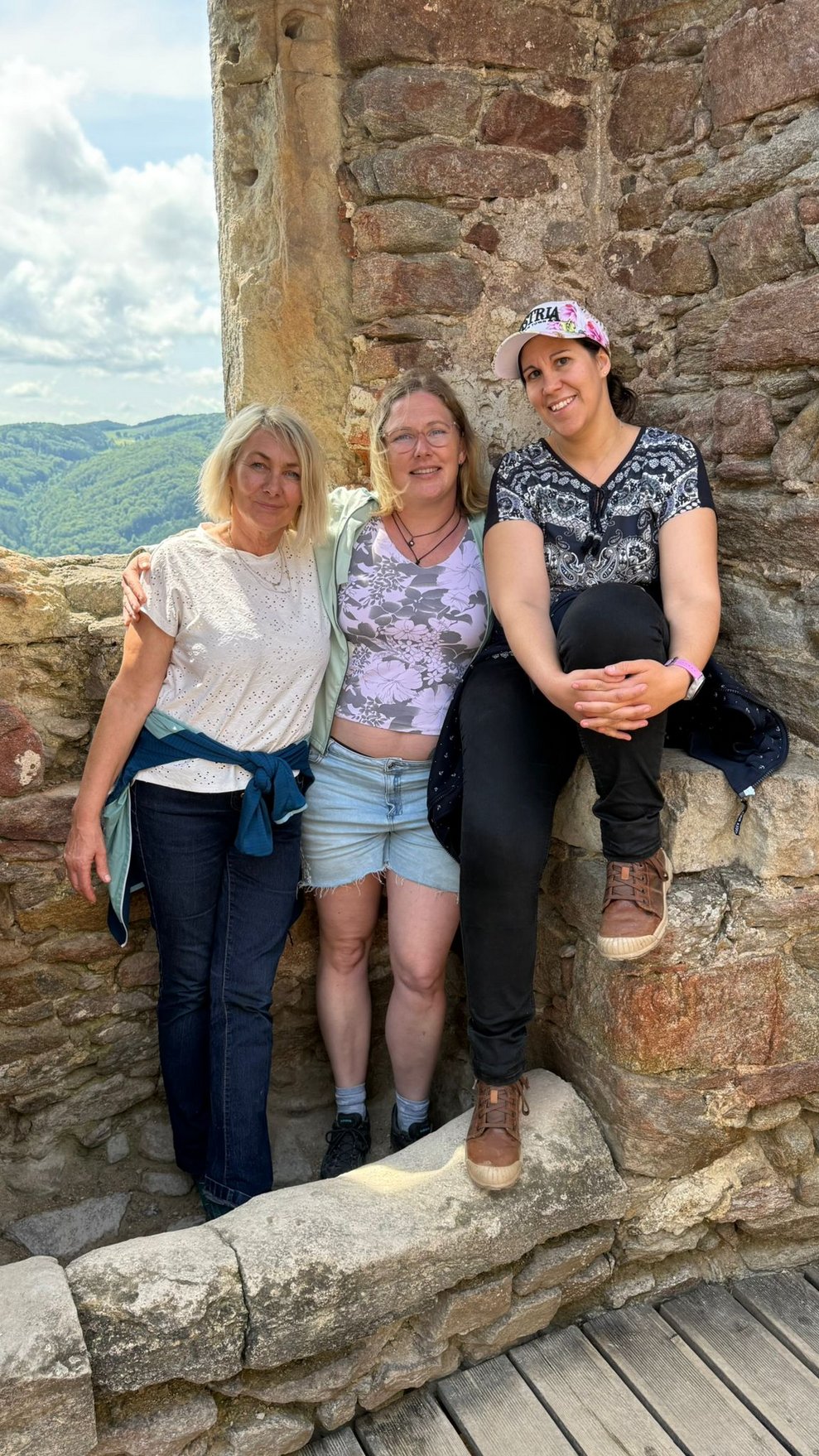 Drei Frauen stehen vor einem Burgfenster dahinter Blick zur Donau