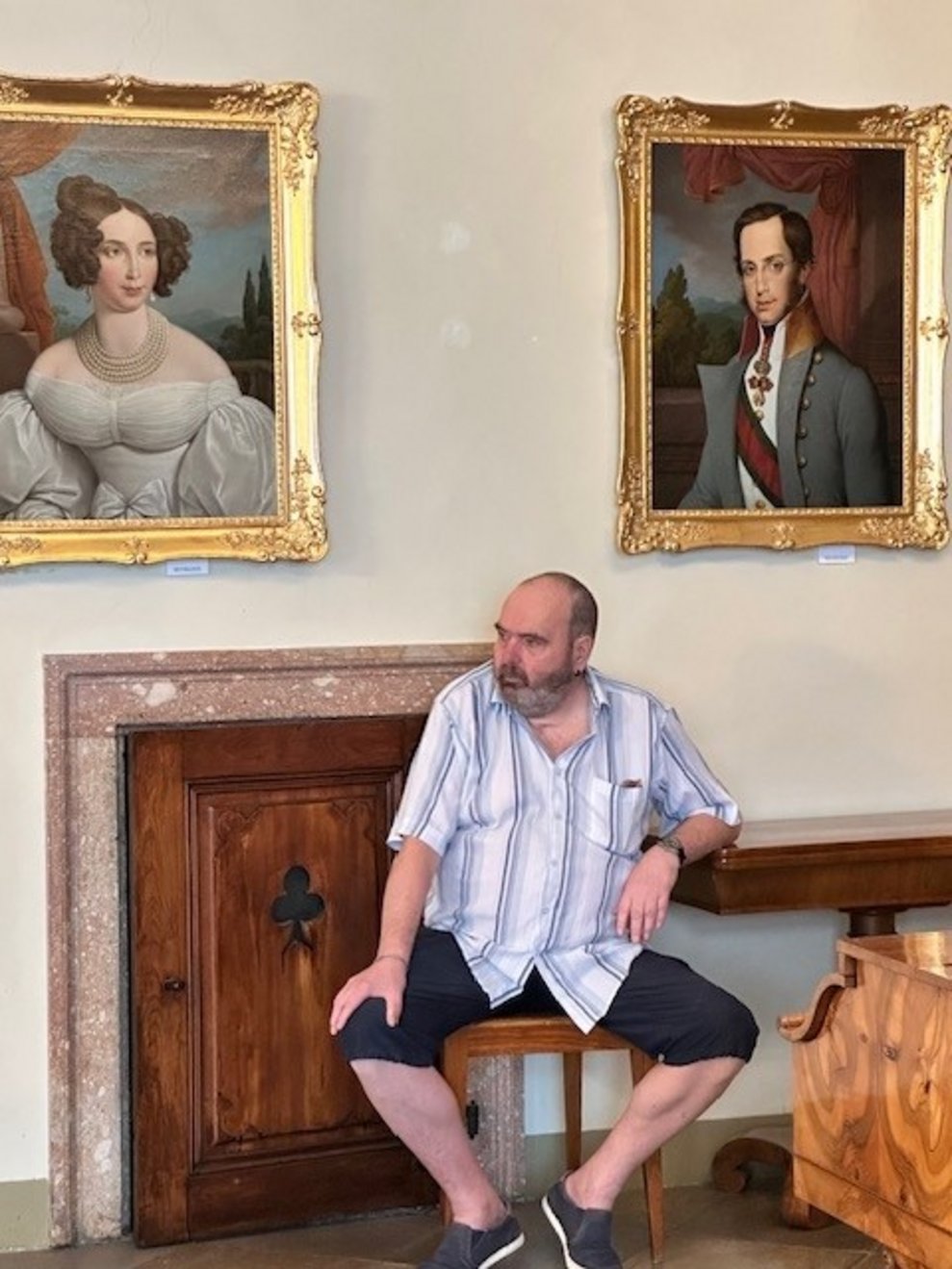 Ein Bewohner sitzt zwischen zwei Gemälden.
