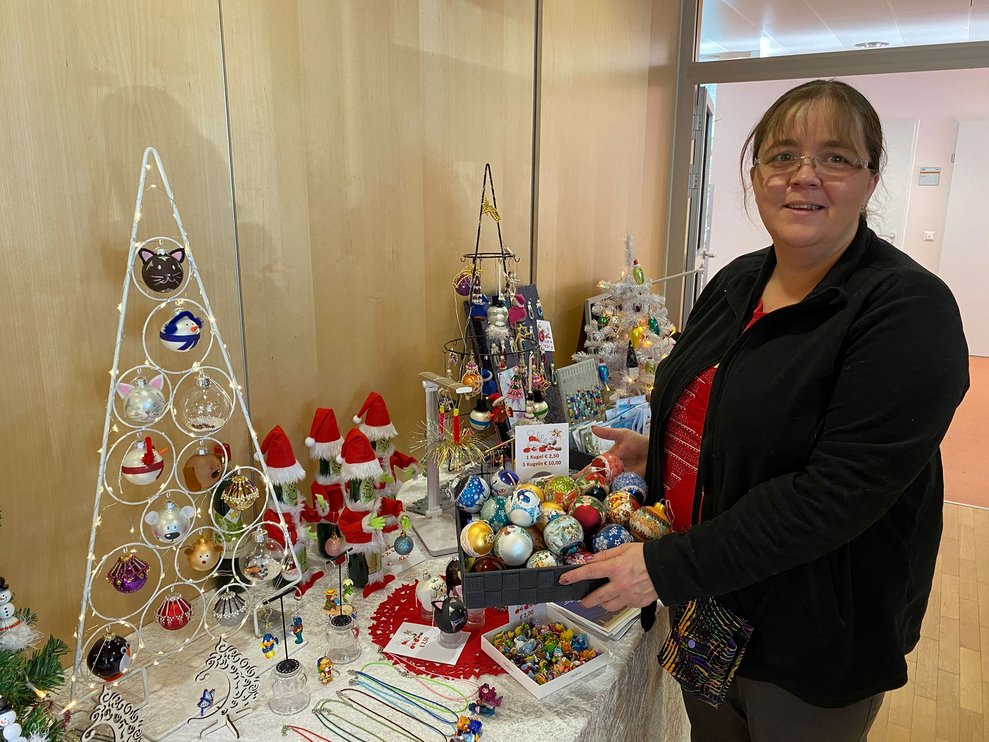 Dame vor ihrem Stand mit verschiedene Weihnachtsdekorationen 