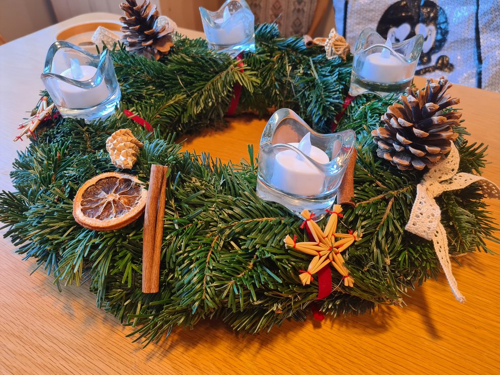 Adventkranz mit Naturdekoration und Ledlichtern.