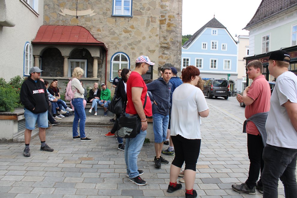 Eine Gruppe von Menschen wartet vor einem Rathaus.