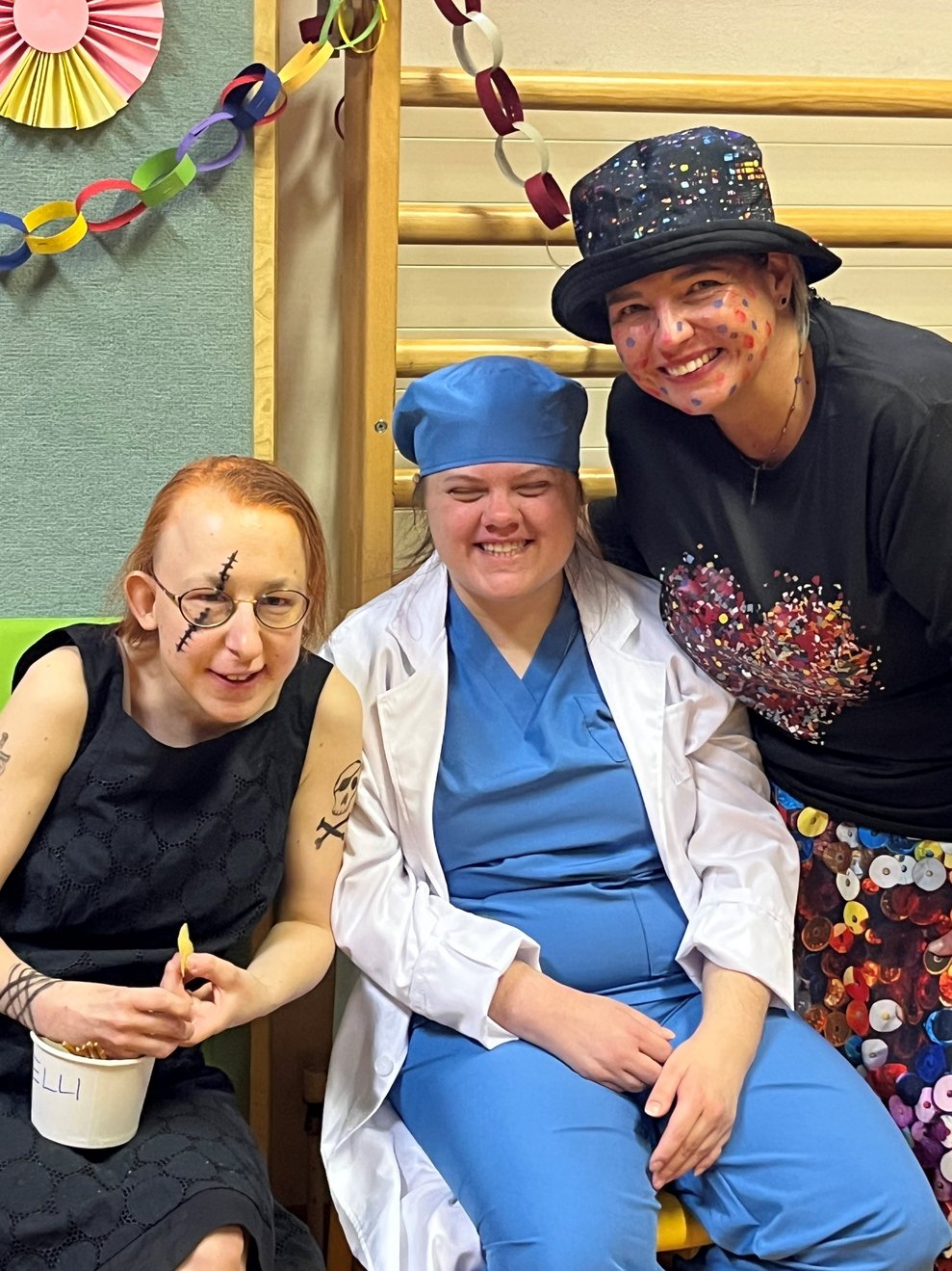 Drei verkleidete Damen sitzen beisammen