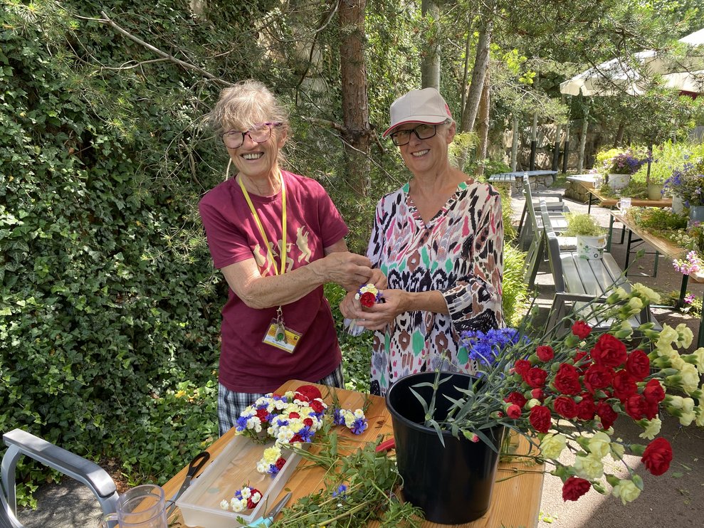 Ehrenamtliche Mitarbeiterinnen Marianne und Christa machen die Anstecksträußchen für die Mitarbeiterinnen.