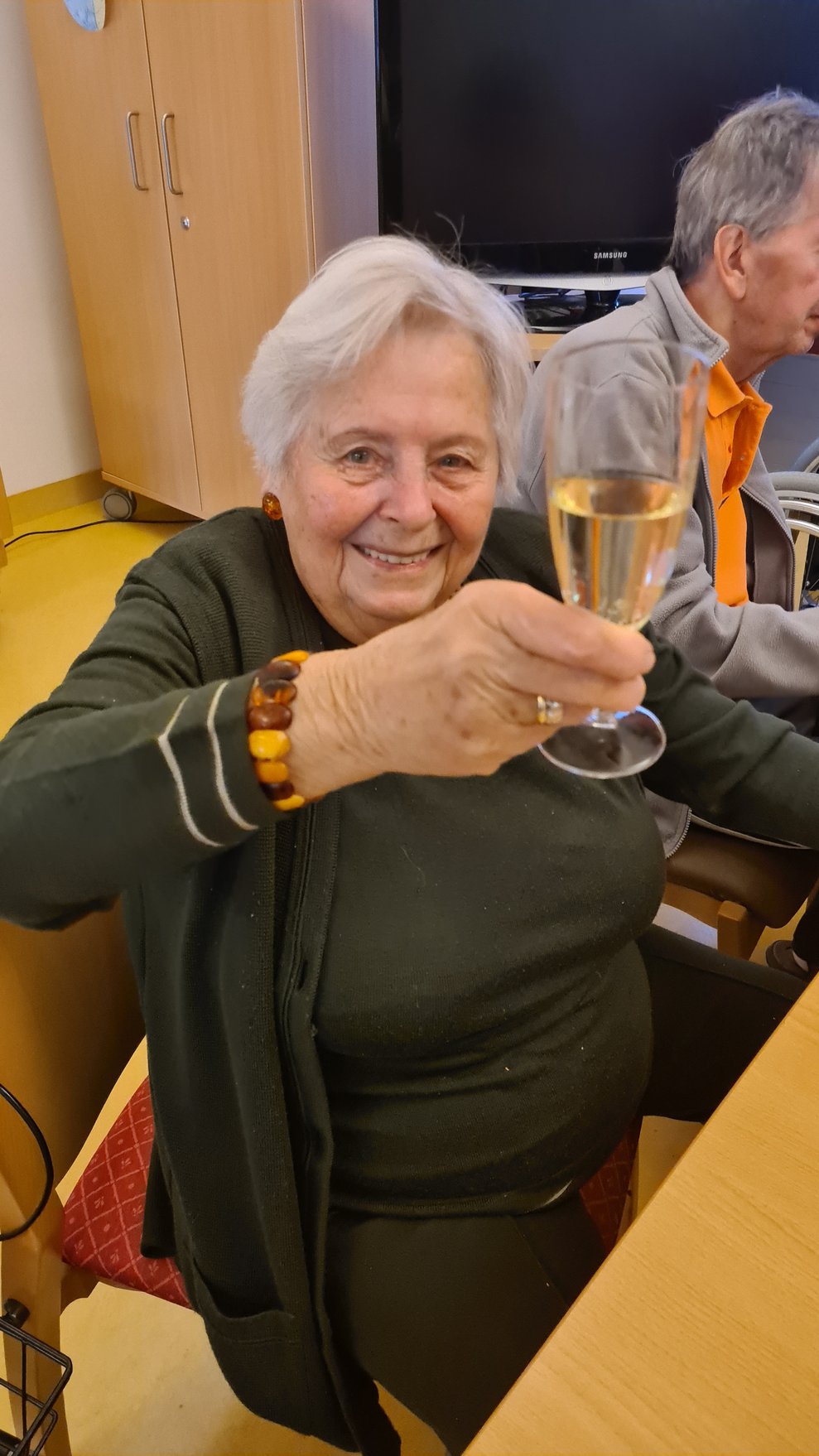 Fr. W mit einem Sekt Gals in der Hand.