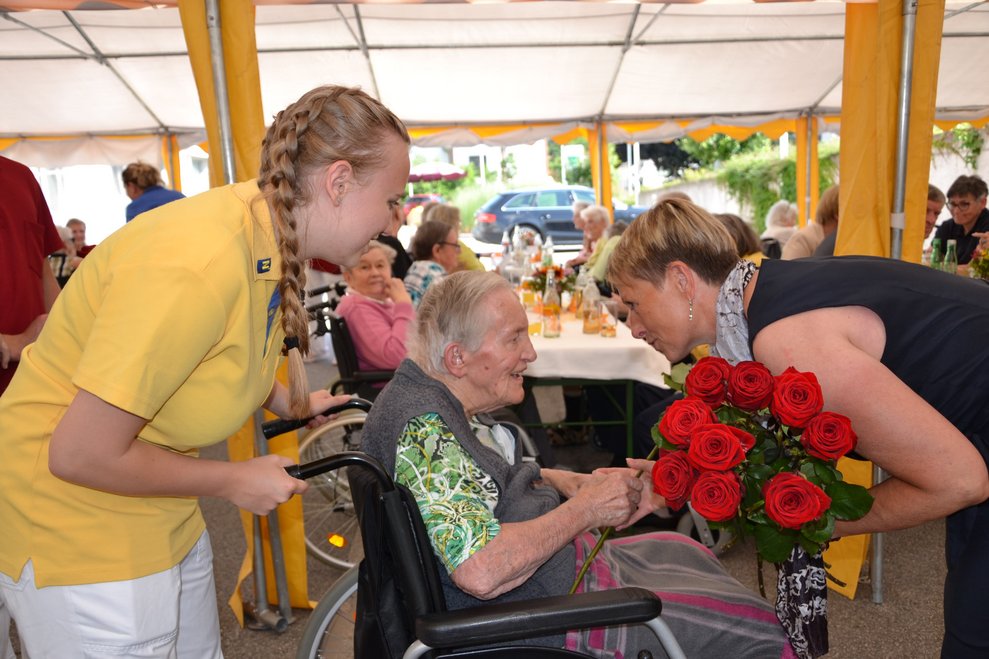 Bewohner überreicht Rose.