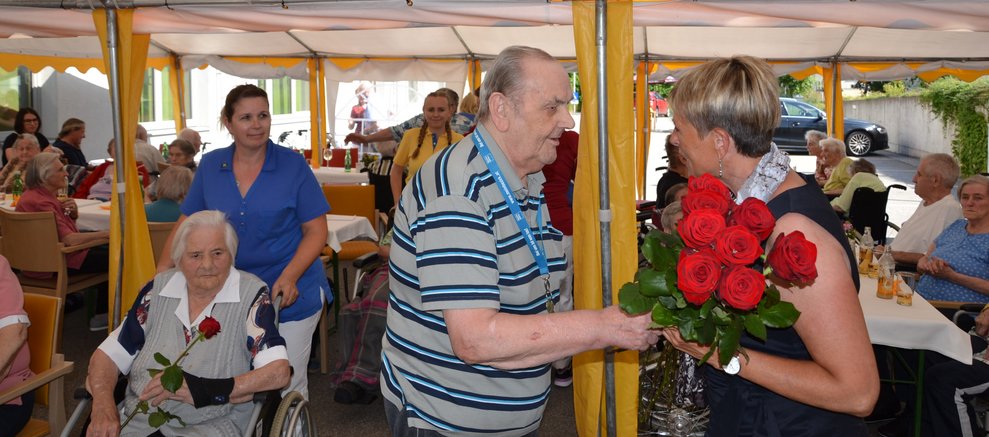 Bewohner überreicht Rose.