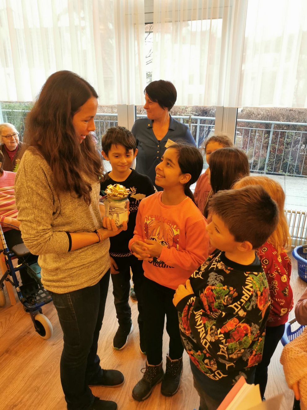 Die Kinder übergeben das Glas mit den guten Wünschen.