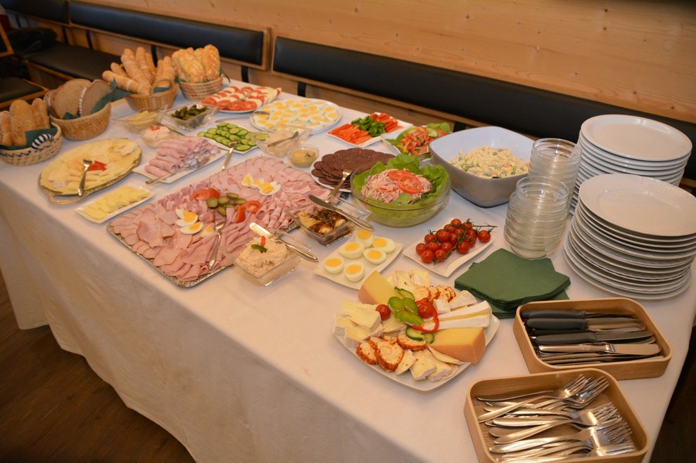 Käse, Wurst, Aufstriche, Gebäck auf Tisch.