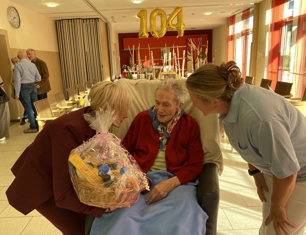 Direktorin Bettina Weiß und Wohnbereichsmanagerin Susanne Koppensteiner gratulieren Frau Anibas seitens des Hauses mit einem Geschenkkorb.
