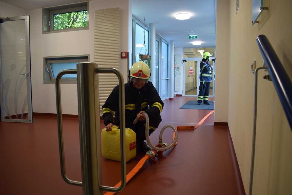 Ein Feuerwehrmann im Inneren des PBZ mit Schlauch und gelben Kanister.