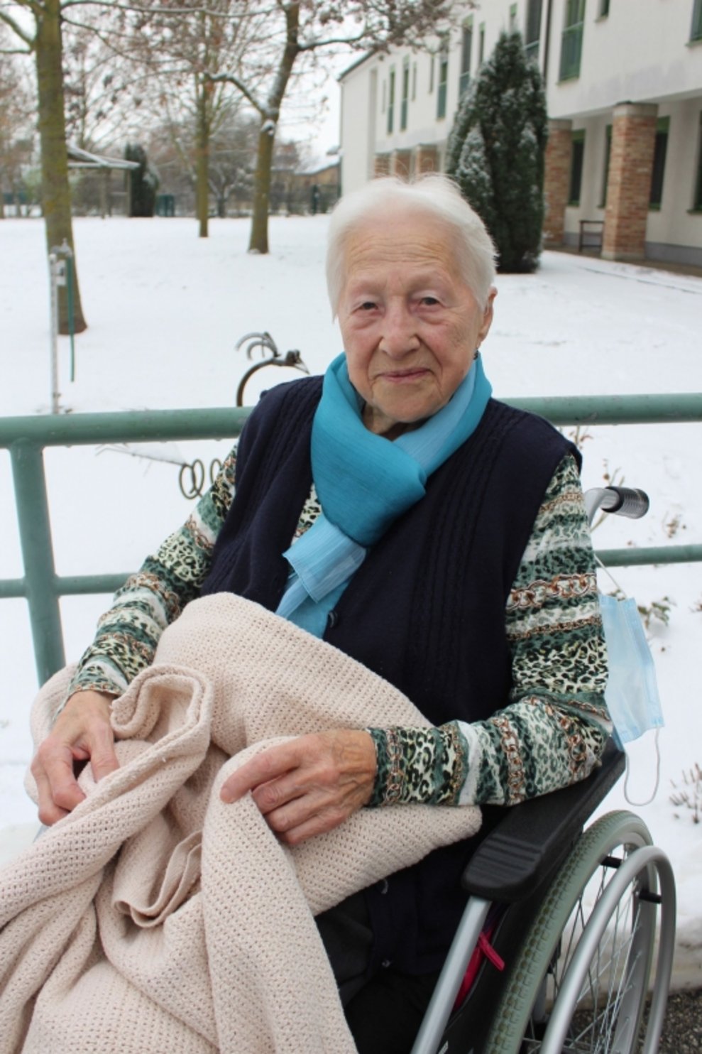Eine Bewohnerin ist draußen beim Schnee.