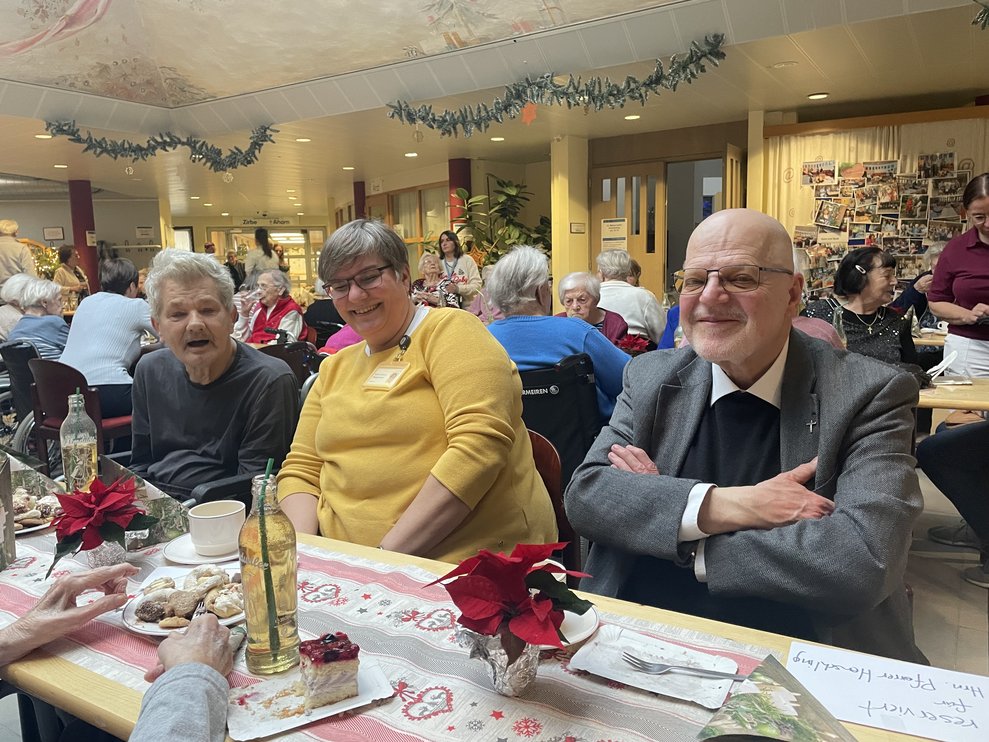Eine Dame und zwei Herren bei der Weihnachtsfeier. 