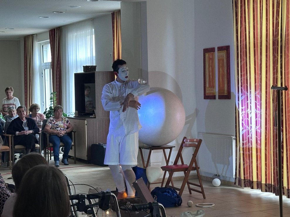 ein Clown bei seiner Vorstellung mit einem großen weißen Ball