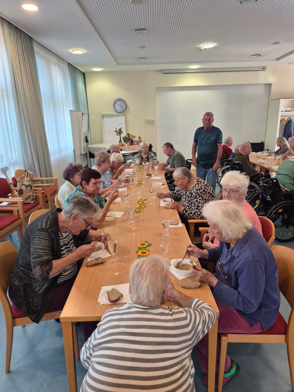 Personen beim Gemüsesuppe und Brot essen.