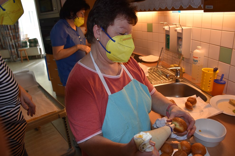 Krapfen werden mit Marmelade gefüllt