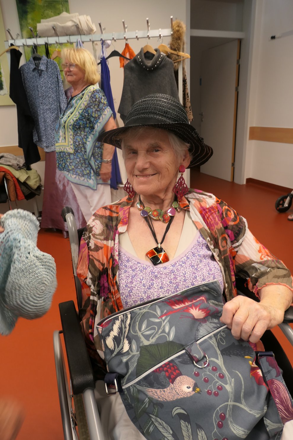 Eine Dame posiert in der Garderobe mit Hut.