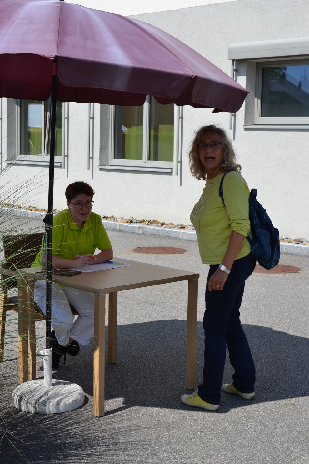 Betreuerin sitzt bei einem Tisch.